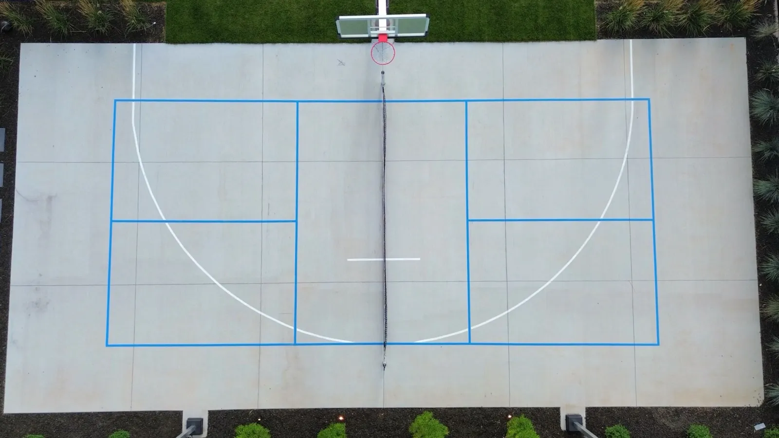 Aerial view of pickleball and basketball lines striped on a backyard concrete court