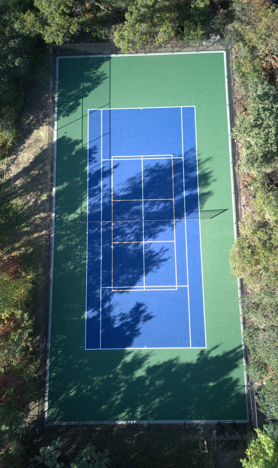 The same tennis court after resurfacing by Grit Courts, blue and green acrylic surface