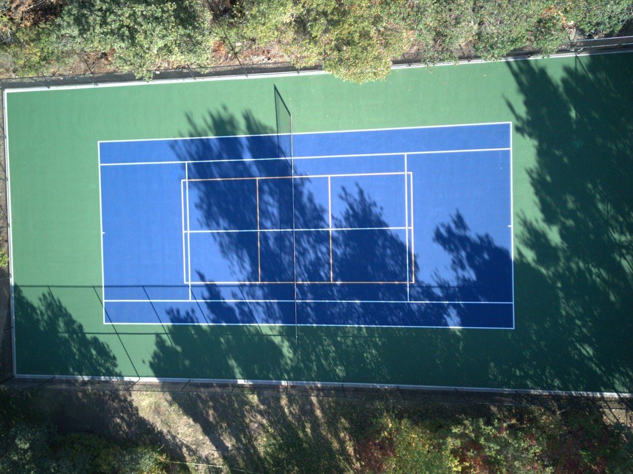 The same tennis court after resurfacing by Grit Courts, blue and green acrylic surface